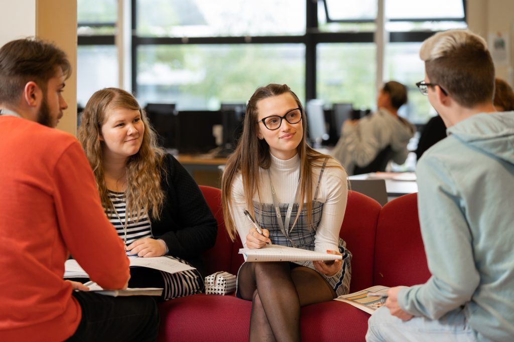 Students have a conversation in a social area